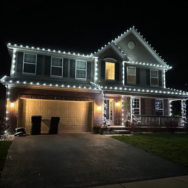 Classic roofline lighting on a suburban home, warm white LEDs outlining eaves and gables