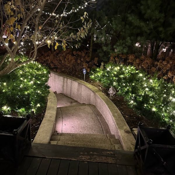 Roofline illumination with wreath over entryway, classic Christmas lighting style