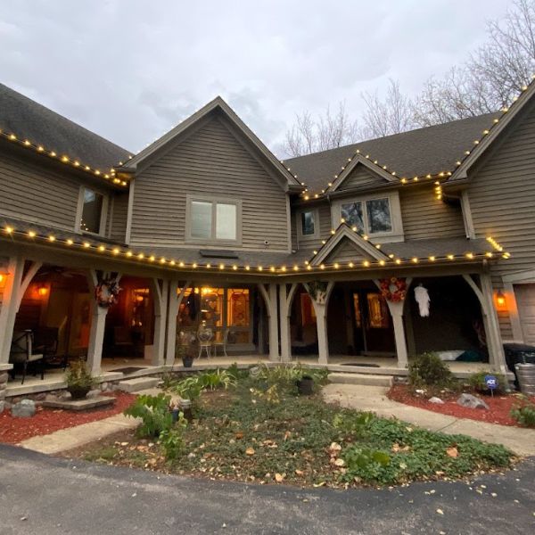 Commercial building facade decorated with holiday lights along roof and windows